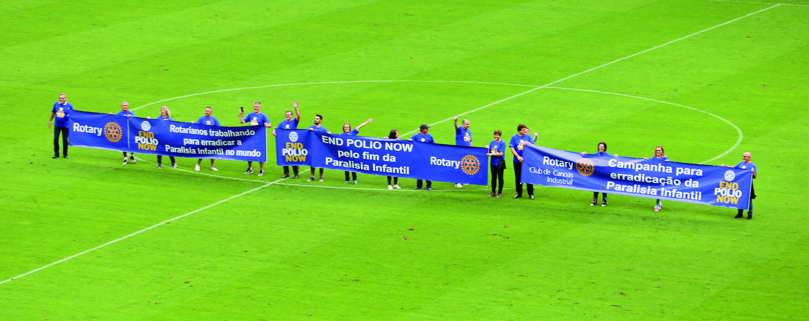 Rotary members in District 4670 carried an End Polio banner out on a football field.
